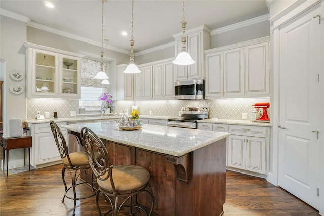 517 Hearth Ter, Argyle, TX 76226 - kitchen featuring stainless steel appliances, a center island, a kitchen bar, white cabinets, and ornamental molding