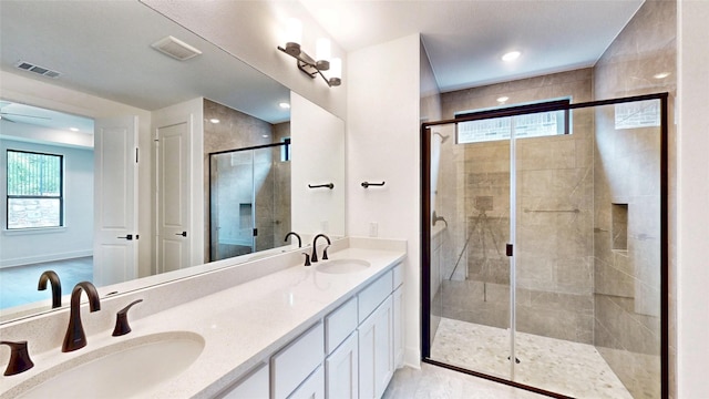 full bath with a shower stall, plenty of natural light, double vanity, and baseboards