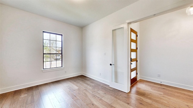 empty room featuring light wood-type flooring and baseboards