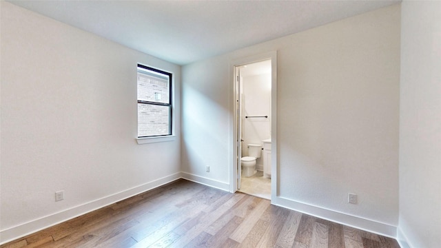 empty room featuring wood finished floors and baseboards