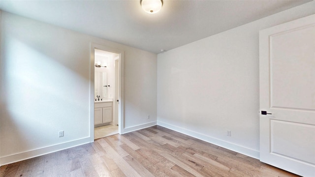 spare room with light wood-style floors and baseboards