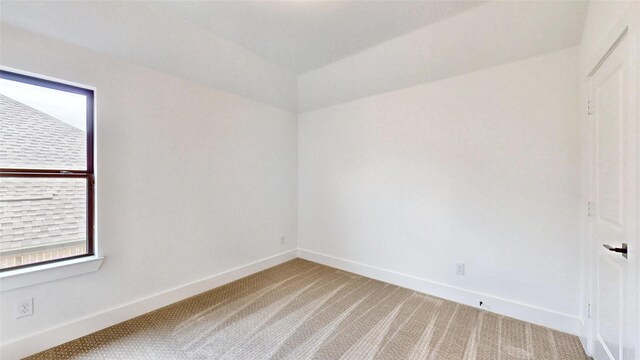 unfurnished room with light colored carpet and baseboards