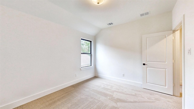 empty room featuring carpet, lofted ceiling, and baseboards