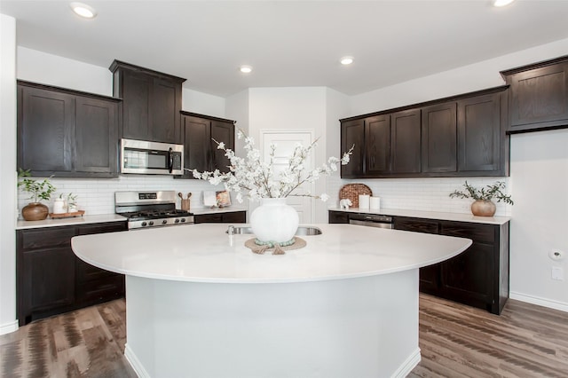 2148 Miramar Dr, Little Elm, TX 75068 - kitchen featuring stainless steel appliances, light countertops, wood finished floors, backsplash, and recessed lighting