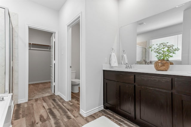2148 Miramar Dr, Little Elm, TX 75068 - full bath with a stall shower, wood finished floors, toilet, a spacious closet, and vanity