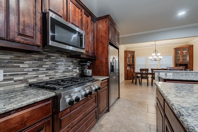 2687 Mcclendon Rd, Weatherford, TX 76088 - kitchen with appliances with stainless steel finishes, backsplash, a chandelier, decorative light fixtures, and crown molding