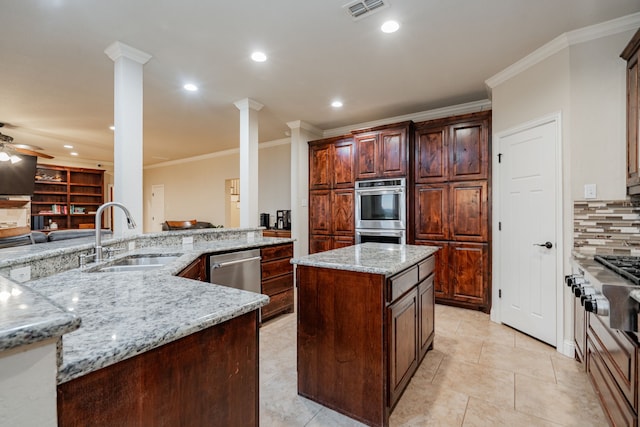 2687 Mcclendon Rd, Weatherford, TX 76088 - kitchen with ornamental molding, a kitchen island, appliances with stainless steel finishes, ceiling fan, and light stone counters