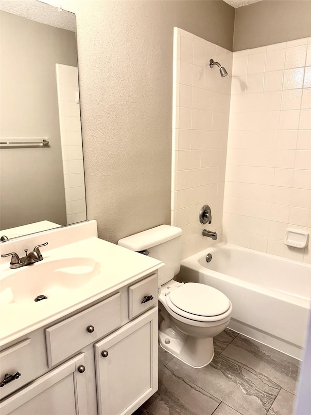 bathroom featuring shower / tub combination, toilet, vanity, and a textured wall