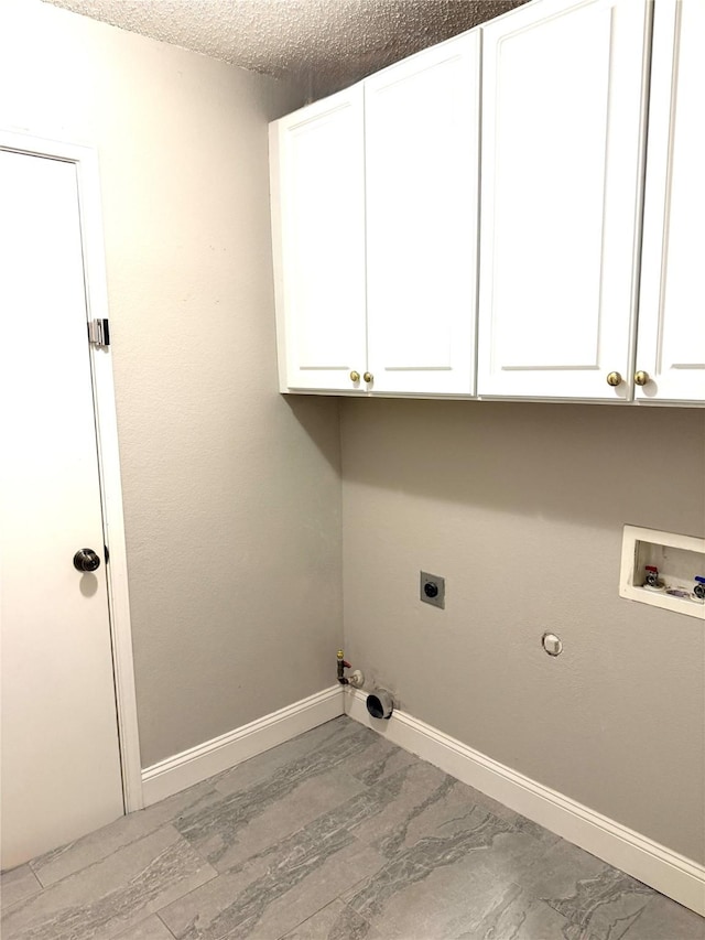 laundry area featuring hookup for a gas dryer, cabinet space, washer hookup, hookup for an electric dryer, and baseboards