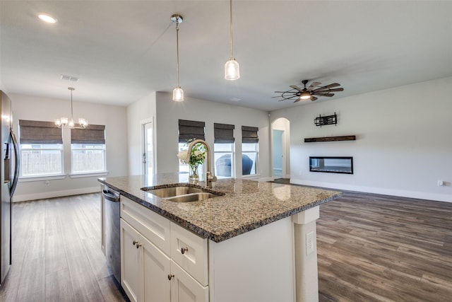 611 Kyle Dr, Tioga, TX 76271 - kitchen with a sink, arched walkways, baseboards, appliances with stainless steel finishes, and dark wood finished floors