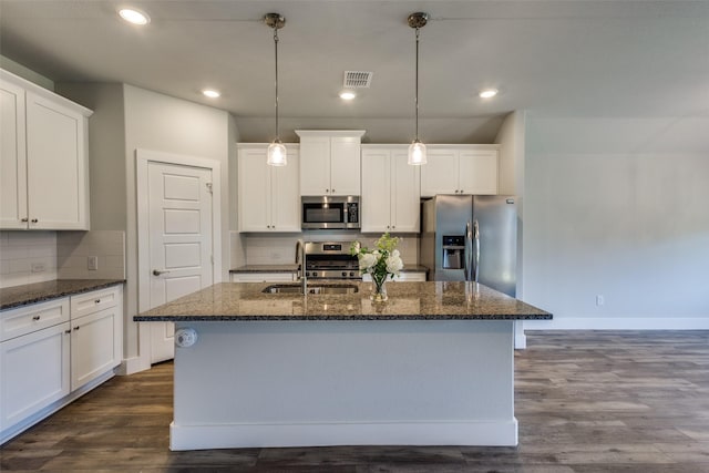 611 Kyle Dr, Tioga, TX 76271 - kitchen featuring appliances with stainless steel finishes, a sink, tasteful backsplash, a kitchen island with sink, and baseboards