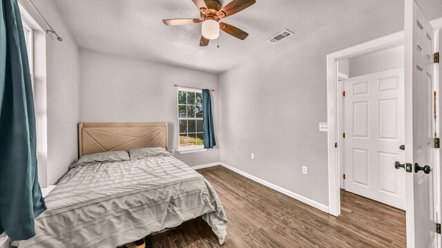 bedroom with wood finished floors, baseboards, and a ceiling fan
