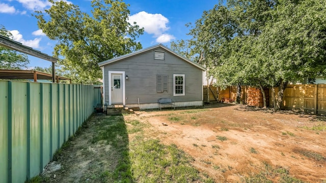 rear view of property with entry steps and a fenced backyard