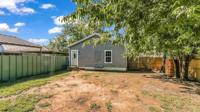 back of house featuring entry steps and a fenced backyard
