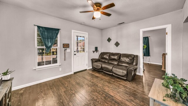 living room with a ceiling fan, dark wood finished floors, and baseboards