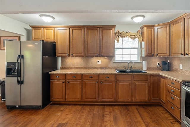 237 Ben Lacy Dr, Gun Barrel City, TX 75156 - kitchen with appliances with stainless steel finishes, a sink, brown cabinetry, dark wood finished floors, and tasteful backsplash