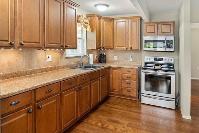 237 Ben Lacy Dr, Gun Barrel City, TX 75156 - kitchen with appliances with stainless steel finishes, a sink, dark wood-type flooring, brown cabinetry, and decorative backsplash