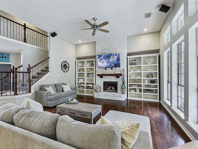 611 Falling Leaf Dr, Allen, TX 75002 - living room featuring a ceiling fan, healthy amount of natural light, wood finished floors, a brick fireplace, and a textured ceiling
