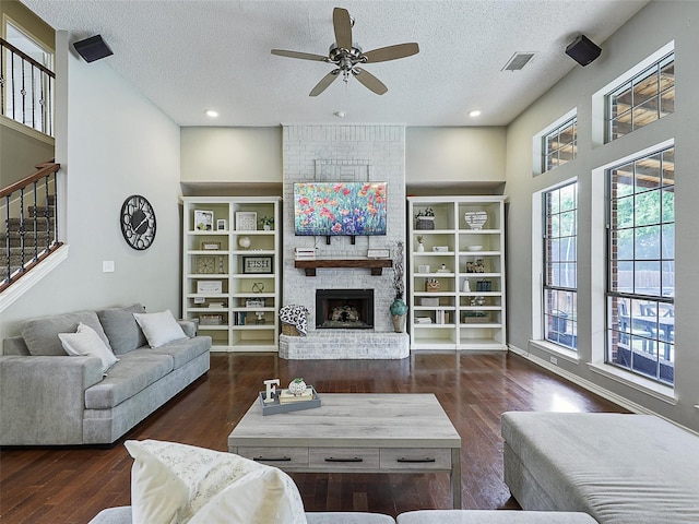 611 Falling Leaf Dr, Allen, TX 75002 - living room featuring a textured ceiling, a ceiling fan, a fireplace, wood finished floors, and stairway