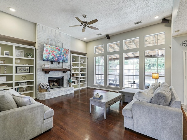 611 Falling Leaf Dr, Allen, TX 75002 - living room with ceiling fan, a textured ceiling, hardwood / wood-style flooring, a brick fireplace, and built in features