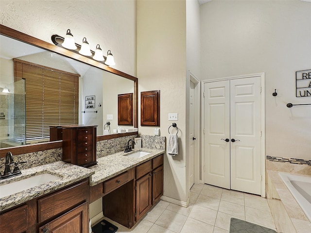 611 Falling Leaf Dr, Allen, TX 75002 - full bathroom with tile patterned floors, a high ceiling, vanity, a relaxing tiled tub, and a closet