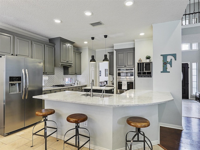 611 Falling Leaf Dr, Allen, TX 75002 - kitchen featuring stainless steel appliances, a sink, a breakfast bar, backsplash, and light stone countertops