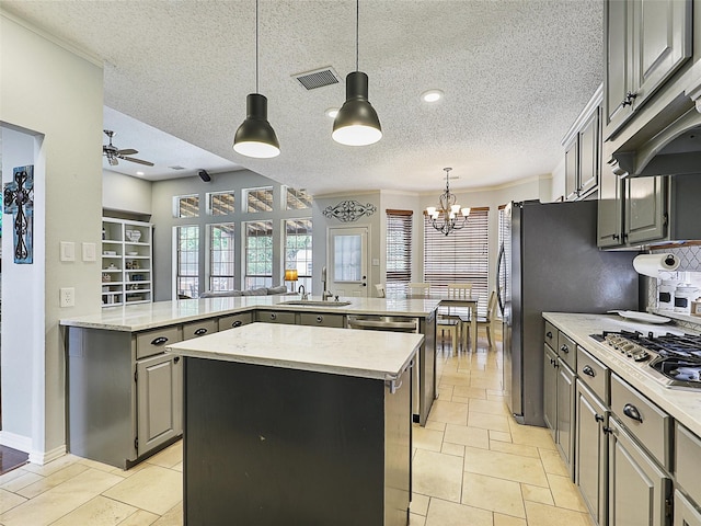 611 Falling Leaf Dr, Allen, TX 75002 - kitchen with stainless steel gas stovetop, a sink, a center island, a textured ceiling, and gray cabinets