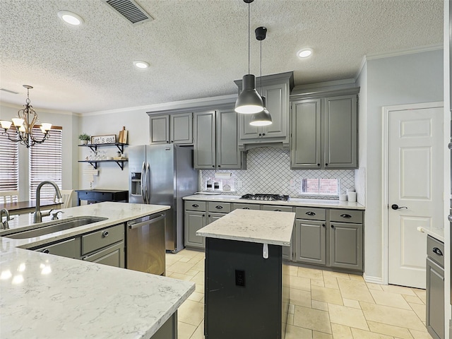 611 Falling Leaf Dr, Allen, TX 75002 - kitchen with a sink, a kitchen island with sink, gray cabinetry, a chandelier, and ornamental molding