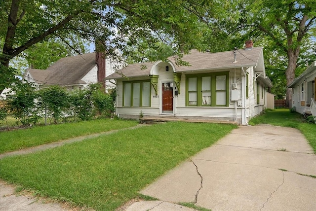 view of front facade with a chimney and a front yard