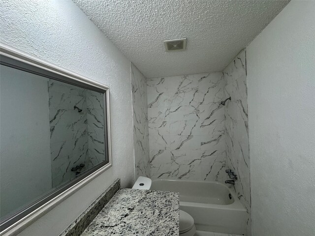 1029 Fox River Ln, Fort Worth, TX 76120 - bathroom featuring a textured ceiling, toilet, a textured wall, and bathtub / shower combination
