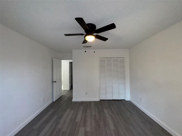 1029 Fox River Ln, Fort Worth, TX 76120 - unfurnished bedroom with dark wood-style flooring, baseboards, a closet, and a textured ceiling