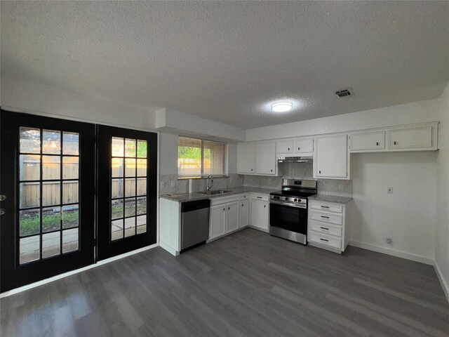 1029 Fox River Ln, Fort Worth, TX 76120 - kitchen with appliances with stainless steel finishes, a textured ceiling, a sink, baseboards, and dark wood-style floors