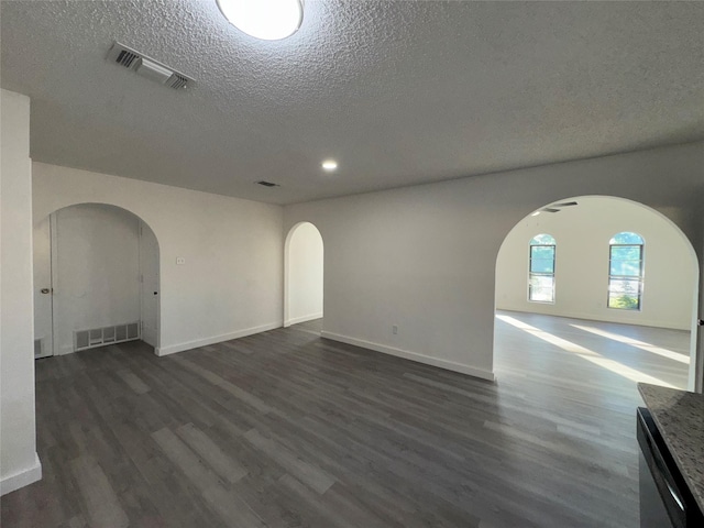1029 Fox River Ln, Fort Worth, TX 76120 - spare room featuring arched walkways, a textured ceiling, dark wood-type flooring, baseboards, and recessed lighting