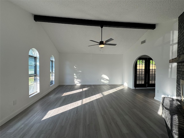 1029 Fox River Ln, Fort Worth, TX 76120 - unfurnished living room featuring beam ceiling, a textured ceiling, a brick fireplace, a ceiling fan, and dark wood-type flooring