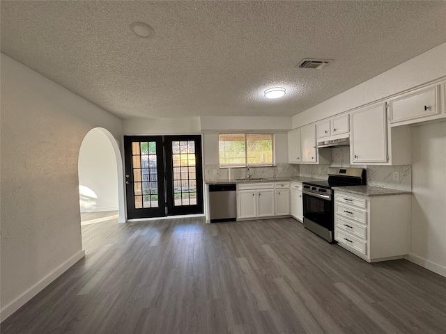 1029 Fox River Ln, Fort Worth, TX 76120 - kitchen featuring appliances with stainless steel finishes, a sink, dark wood-style flooring, a textured ceiling, and white cabinets