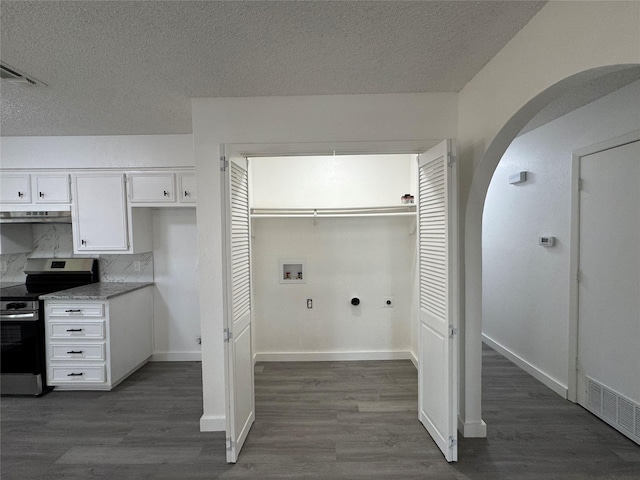 1029 Fox River Ln, Fort Worth, TX 76120 - washroom with arched walkways, hookup for a washing machine, dark wood finished floors, a textured ceiling, and baseboards
