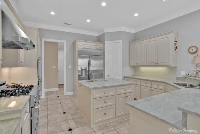 11911 Longfellow Cir, Shreveport, LA 71106 - kitchen featuring appliances with stainless steel finishes, wall chimney range hood, a sink, decorative backsplash, and light stone counters