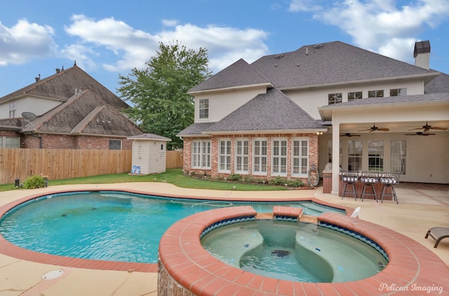 11911 Longfellow Cir, Shreveport, LA 71106 - view of swimming pool featuring a ceiling fan, a pool with connected hot tub, fence, a patio, and an outdoor structure