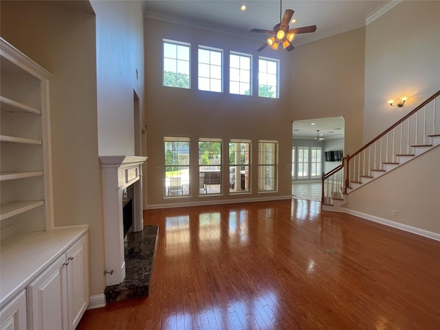 11911 Longfellow Cir, Shreveport, LA 71106 - unfurnished living room featuring ceiling fan, wood finished floors, a premium fireplace, ornamental molding, and baseboards