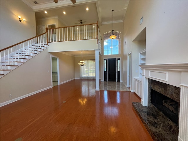 11911 Longfellow Cir, Shreveport, LA 71106 - unfurnished living room with a towering ceiling, crown molding, ceiling fan, stairway, and a premium fireplace