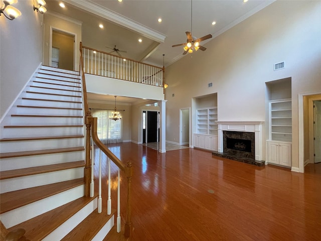 11911 Longfellow Cir, Shreveport, LA 71106 - unfurnished living room featuring ornamental molding, a towering ceiling, a ceiling fan, a fireplace, and built in shelves