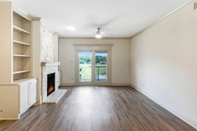 8511 Westover Ct Unit 235, Granbury, TX 76049 - unfurnished living room featuring a large fireplace, dark wood-type flooring, baseboards, ceiling fan, and built in shelves