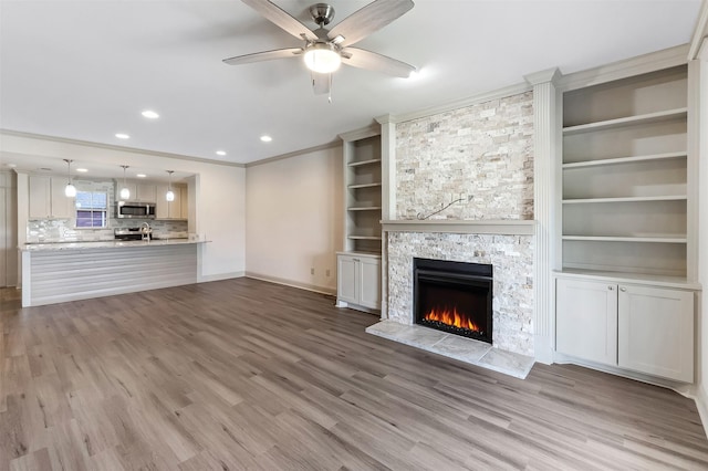 8511 Westover Ct Unit 235, Granbury, TX 76049 - unfurnished living room featuring a fireplace, ceiling fan, wood finished floors, baseboards, and recessed lighting