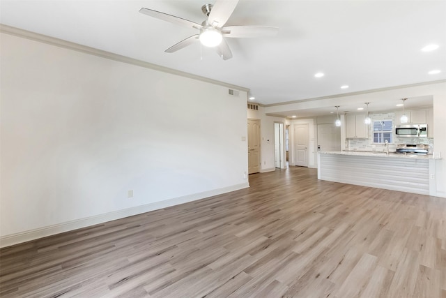 8511 Westover Ct Unit 235, Granbury, TX 76049 - unfurnished living room featuring crown molding, a sink, recessed lighting, ceiling fan, and light wood finished floors