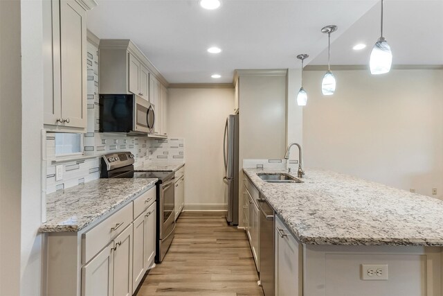 8511 Westover Ct Unit 235, Granbury, TX 76049 - kitchen with stainless steel appliances, a sink, a peninsula, light wood finished floors, and backsplash