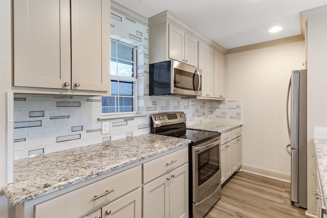 8511 Westover Ct Unit 235, Granbury, TX 76049 - kitchen featuring appliances with stainless steel finishes, light wood-type flooring, backsplash, baseboards, and light stone countertops