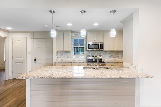 8511 Westover Ct Unit 235, Granbury, TX 76049 - kitchen featuring appliances with stainless steel finishes, light wood finished floors, tasteful backsplash, a sink, and light stone countertops