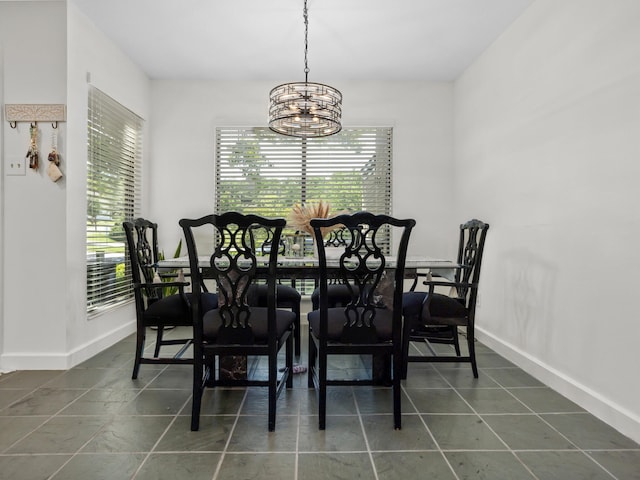 2633 Mccart Ave, Fort Worth, TX 76110 - dining room with a chandelier, baseboards, and dark tile patterned flooring