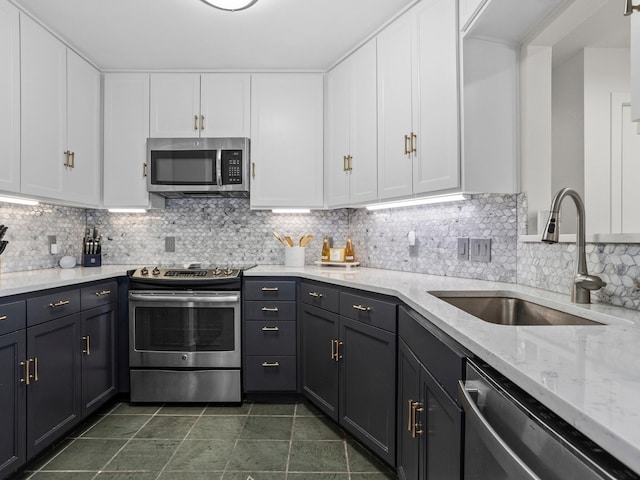 2633 Mccart Ave, Fort Worth, TX 76110 - kitchen with stainless steel appliances, a sink, white cabinets, and backsplash