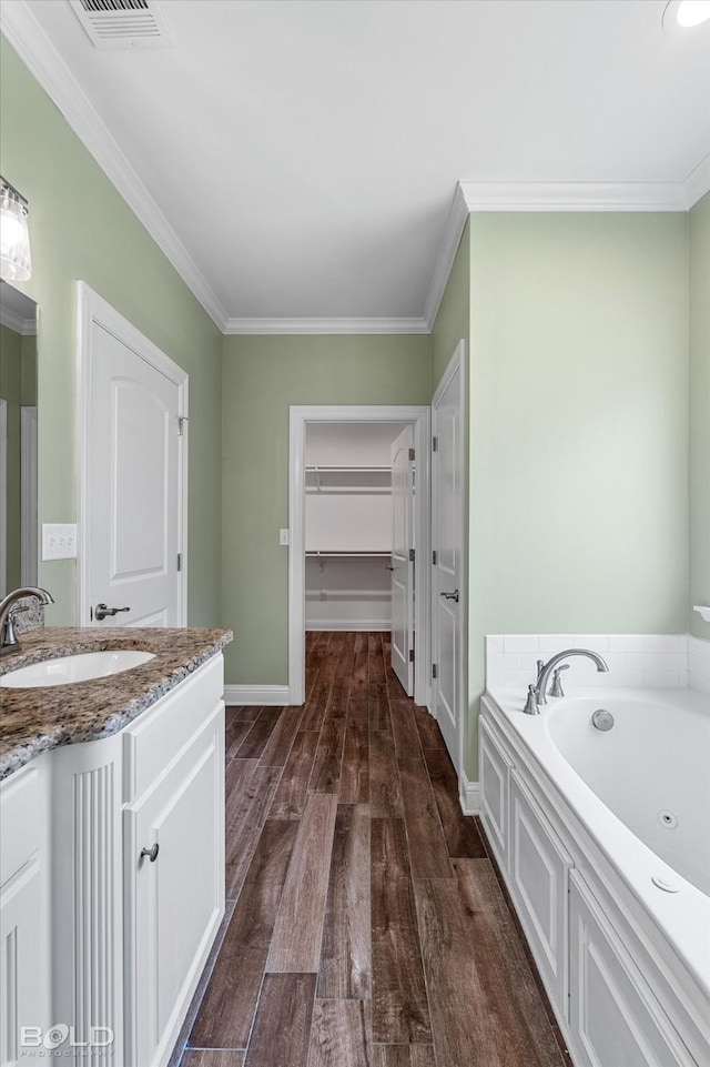 9420 N Pointe Cir, Greenwood, LA 71033 - full bath with wood finished floors, a garden tub, a walk in closet, vanity, and ornamental molding